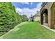 Expansive backyard with lush green lawn, mature trees, and an elegant brick home with a balcony at 8340 Royal Melbourne Way, Duluth, GA 30097