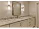 Modern bathroom vanity featuring stone countertop, white cabinets, and stylish lighting fixtures at 8340 Royal Melbourne Way, Duluth, GA 30097