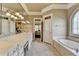 Bright bathroom featuring a double vanity with a large mirror and a soaking tub at 8340 Royal Melbourne Way, Duluth, GA 30097