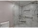 Modern bathroom with glass-enclosed shower and stylish tile work, and corner shelf at 8340 Royal Melbourne Way, Duluth, GA 30097