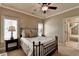 Bedroom with shutters, crown molding, and a ceiling fan over a queen bed at 8340 Royal Melbourne Way, Duluth, GA 30097