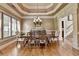Formal dining room featuring hardwood floors, large window and custom trim and a decorative chandelier at 8340 Royal Melbourne Way, Duluth, GA 30097