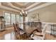 Elegant dining room featuring hardwood floors, a chandelier, and a large table, ideal for formal gatherings at 8340 Royal Melbourne Way, Duluth, GA 30097
