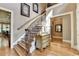 Elegant foyer with hardwood floors, staircase with wrought iron railings, and decorative furniture at 8340 Royal Melbourne Way, Duluth, GA 30097