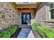 Inviting front entrance with stone and brick accents, complemented by manicured hedges and a stylish double door at 8340 Royal Melbourne Way, Duluth, GA 30097