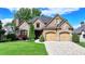 Charming home with a stone and brick facade, manicured lawn, and a paved driveway leading to a two-car garage at 8340 Royal Melbourne Way, Duluth, GA 30097