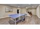 Open game room with a ping pong table and adjacent stairway at 8340 Royal Melbourne Way, Duluth, GA 30097
