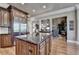 Kitchen island featuring granite countertops, wood cabinets, stainless steel refrigerator and hardwood floors at 8340 Royal Melbourne Way, Duluth, GA 30097