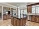 Elegant kitchen with a large island, stainless steel appliances, wood cabinets, and hardwood floors at 8340 Royal Melbourne Way, Duluth, GA 30097