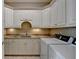 Laundry room featuring granite counters, white cabinets, and modern appliances at 8340 Royal Melbourne Way, Duluth, GA 30097
