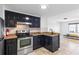 Modern kitchen with stainless steel appliances, dark cabinets, and a view into the bedroom at 199 14Th Ne St # 2312, Atlanta, GA 30309