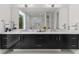 Bathroom featuring a double vanity with a marble countertop, dark cabinets, and a large mirror at 2385 Nesbitt Dr, Brookhaven, GA 30319