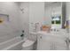 Cozy bathroom featuring white fixtures, white marbled walls and a shower and bathtub combination at 2385 Nesbitt Dr, Brookhaven, GA 30319