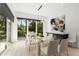 Bright dining room with glass table, modern lighting, and large windows offering backyard views at 2385 Nesbitt Dr, Brookhaven, GA 30319