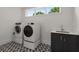 Modern laundry room featuring a front load washer and dryer, sink and patterned tile floor at 2385 Nesbitt Dr, Brookhaven, GA 30319