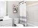 Bright bathroom featuring a shower with a white curtain, white toilet, and modern sink at 3062 Cambridge Mill St, Acworth, GA 30102