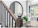Entryway with decorative mirror, wooden railing, and white floral arrangement adds warmth and style at 3062 Cambridge Mill St, Acworth, GA 30102