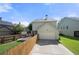 Backyard view showcasing a two-car garage, a wood fence, and a well-maintained lawn, with lush landscaping at 3826 Baxley Village Trl, Suwanee, GA 30024
