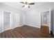 Bedroom featuring hardwood floors, a ceiling fan, and multiple closets and door to ensuite bathroom at 3826 Baxley Village Trl, Suwanee, GA 30024