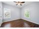 Bright bedroom featuring hardwood floors, neutral paint, a ceiling fan, and large windows at 3826 Baxley Village Trl, Suwanee, GA 30024
