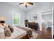 Bedroom featuring hardwood floors, a ceiling fan, a dresser, and a door to a walkway at 3826 Baxley Village Trl, Suwanee, GA 30024