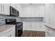 Modern kitchen with white cabinetry, stainless steel appliances, stylish backsplash and hardwood floors at 3826 Baxley Village Trl, Suwanee, GA 30024