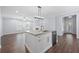Bright, updated kitchen with an island, stainless steel dishwasher, hardwood floors, and open layout to living area at 3826 Baxley Village Trl, Suwanee, GA 30024