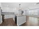 Open concept kitchen featuring a large island, modern appliances, and hardwood floors flowing into the living area at 3826 Baxley Village Trl, Suwanee, GA 30024