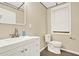A functional bathroom includes a vanity with a large sink, toilet and a window for natural light at 4353 White Oak Dr, Sugar Hill, GA 30518