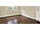 Bright bedroom featuring hardwood floors and a window, with view of greenery at 4353 White Oak Dr, Sugar Hill, GA 30518