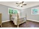 Light and airy bedroom with wood floors, a ceiling fan, and views of the outdoors at 4353 White Oak Dr, Sugar Hill, GA 30518