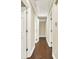 Hallway with hardwood floors and neutral paint, leading to various rooms in the house at 4353 White Oak Dr, Sugar Hill, GA 30518
