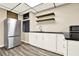 A quaint kitchenette boasts a stainless fridge, sleek black countertops and complementary floating shelves at 4353 White Oak Dr, Sugar Hill, GA 30518