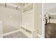 Mudroom area with coat rack, bench, and shelving for organization, and access to the kitchen at 4353 White Oak Dr, Sugar Hill, GA 30518