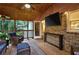 Screened-in porch with comfortable seating, mounted tv, and brick wall at 4353 White Oak Dr, Sugar Hill, GA 30518