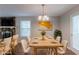 Staged dining room featuring a modern chandelier, wood table, and a view of the living room at 6015 Sumit Nw Ct, Kennesaw, GA 30152