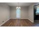 Charming dining area featuring hardwood floors, a modern light fixture, and a door to the backyard at 6015 Sumit Nw Ct, Kennesaw, GA 30152