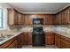 Kitchen featuring wood cabinets, granite countertops, and modern appliances at 6015 Sumit Nw Ct, Kennesaw, GA 30152