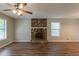 Living room with wood flooring, ceiling fan, and stone fireplace, offering a cozy and inviting atmosphere at 6015 Sumit Nw Ct, Kennesaw, GA 30152