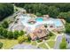 Aerial view of community pool, lazy river, water slides, and clubhouse surrounded by mature trees and landscaping at 101 Misty Valley Dr, Canton, GA 30114
