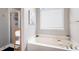 Bright bathroom featuring a soaking tub with caddy and a glass-enclosed shower at 101 Misty Valley Dr, Canton, GA 30114