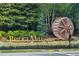 Stone signage for BridgeMill community, featuring a decorative water wheel and landscaping at 101 Misty Valley Dr, Canton, GA 30114