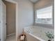 Bright bathroom featuring a soaking tub with jets and a window at 200 Eva Way Ne, Cartersville, GA 30121