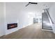 Open-concept living room featuring an electric fireplace, light floors and an adjoining kitchen at 262 Crumley St Sw, Atlanta, GA 30312