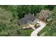 A stunning aerial view showcases the home's landscaped driveway and surrounding mature trees in a lush, green setting at 2682 Boulder Creek Ne Dr, Roswell, GA 30075