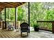 Cozy covered back porch with seating, offering a serene view of the surrounding wooded area at 2682 Boulder Creek Ne Dr, Roswell, GA 30075