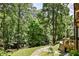 Backyard with mature trees, and lush landscaping, with a stone pathway leading to the forest at 2682 Boulder Creek Ne Dr, Roswell, GA 30075