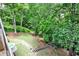 Lush backyard featuring tiered landscaping, a stone walkway, and mature trees at 2682 Boulder Creek Ne Dr, Roswell, GA 30075