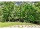 Picturesque backyard featuring a gentle stream and stone pathway through the wooded landscape at 2682 Boulder Creek Ne Dr, Roswell, GA 30075