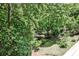 Lush backyard view with mature trees and a small creek running through the property at 2682 Boulder Creek Ne Dr, Roswell, GA 30075